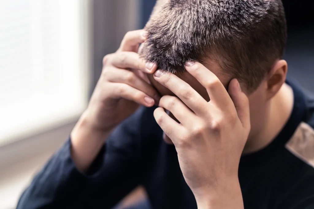 A man with his hand in his head feeling stressed
