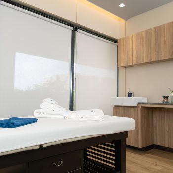 The relaxing massage room at Horizon with bed and candles.